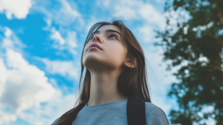 TMS Therapy for Adolescents A New Hope in Teen Depression Treatment A teenager with a backpack looking up at a blue sky | TMS Therapy for Adolescents: A New Hope in Teen Depression Treatment | Mindful Health Solutions