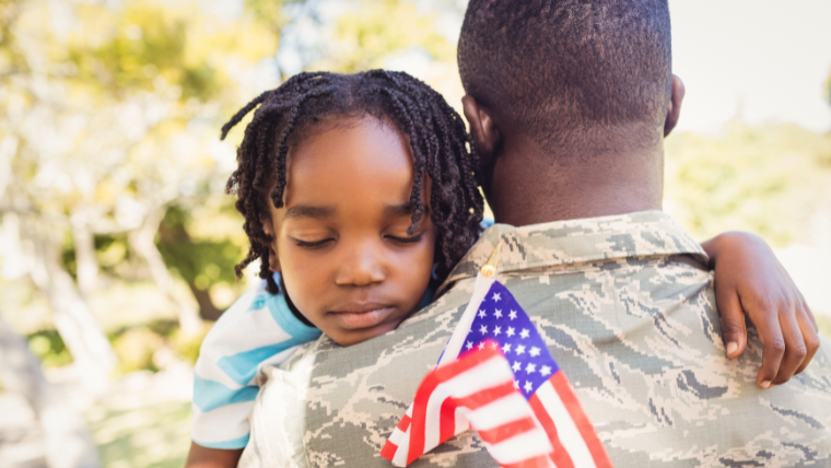 More-Mental-Health-Needed-for-Black-Veterans A veteran carrying his son | Black Veterans Need More Access to Mental Health Services | Mindful Health Solutions
