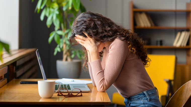 How to Request a Mental Health Day Achieving Work-Life Balance with Time Off Woman at her desk with her head in her hands | How to Request a Mental Health Day Achieving Work-Life Balance with Time Off