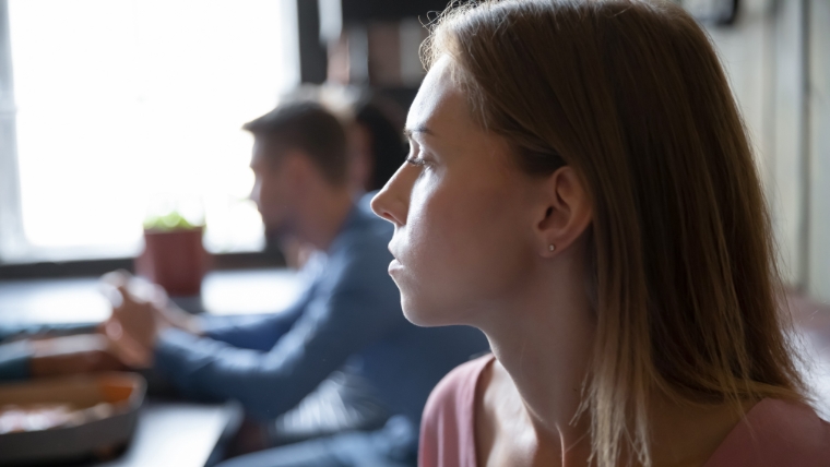 Woman looking at man who is staring at his phone | 8 Effective Strategies for Dealing with Passive-Aggressive Individuals | Mindful Health Solutions