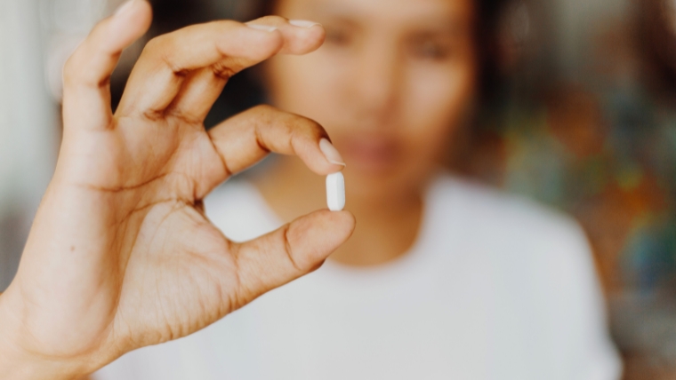 The-Influence-of-Antidepressants-on-the-Brain-A-Comprehensive-Guide Person holding pill up close to the camera | The Influence of Antidepressants on the Brain: A Comprehensive Guide | Mindful Health Solutions
