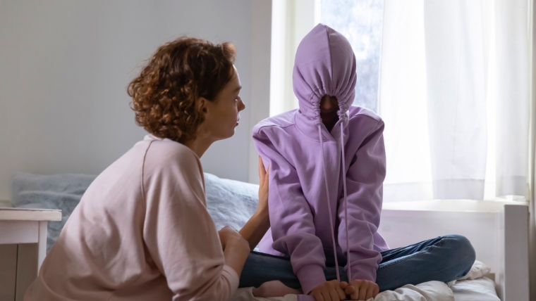 How-Parental-Depression-Affects-Kids-The-True-Impact-of-Depression Young teen daughter pulls hood over face as her mother tries to speak with her | How Parental Depression Affects Kids The True Impact of Depression | Mindful Health Solutions