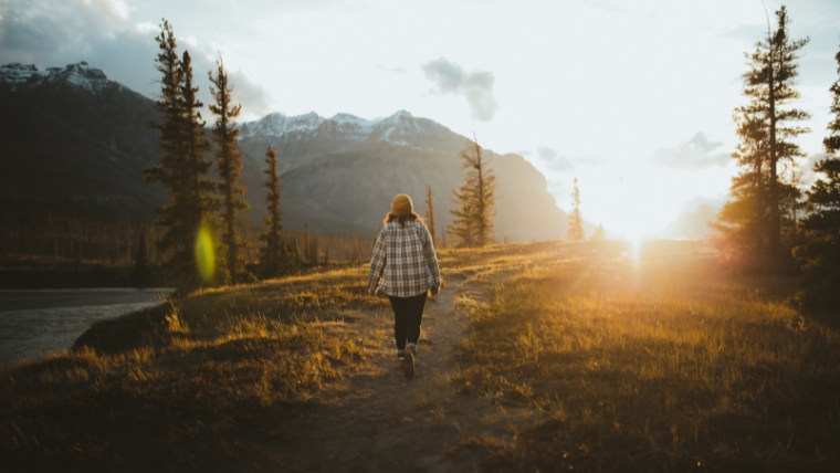 Set-These-10-New-Years-Resolutions-to-Help-Overcome-Depression Woman walking in nature towards the sun | Set These 10 New Year's Resolutions to Help Overcome Depression | Mindful Health Solutions