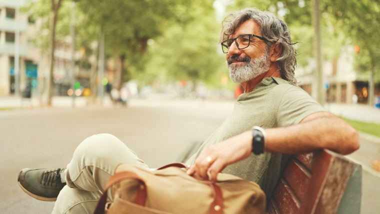 Are-You-Suffering-from-Chronic-Pain-Find-Hope-with-TMS Older man siting on a bench in a city smiling | Are You Suffering from Chronic Pain? Find Hope with TMS | Mindful Health Solutions