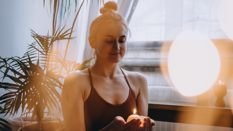 Celebrate Self-Love Expert Strategies to Embrace Valentine’s Day After a Breakup Woman smiling to herself while holding a candle | Celebrate Self-Love Expert Strategies to Embrace Valentine's Day After a Breakup | Mindful Health Solutions