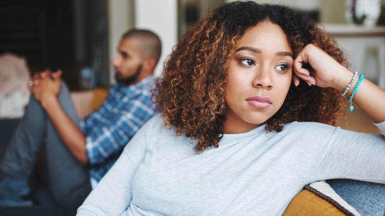 Is-Your-Relationship-Hurting-Your-Mental-Health-5-Common-Red-Flags Unhappy couple and sad woman upset after argument or conflict with her partner while sitting on couch at home | Is Your Relationship Hurting Your Mental Health 5 Common Red Flags | Mindful Health Solutions