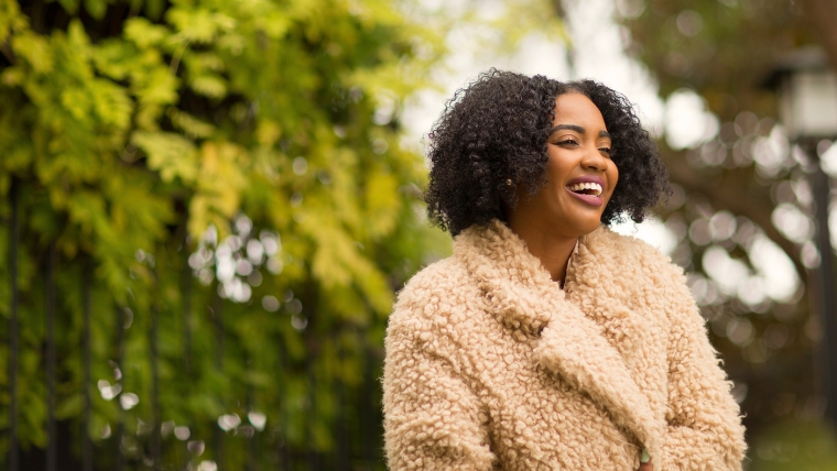 Need-a-Confidence-Boost-10-Powerful-Ways-that-Will-Raise-Your-Mental-Health A woman in a coat outside smiling | Need a Confidence Boost 10 Powerful Ways that Will Raise Your Mental Health | Mindful Health Solutions
