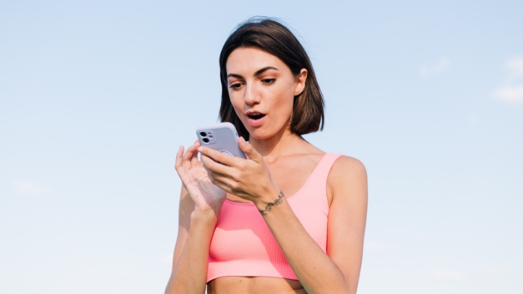 Strange-But-True-7-TMS-Side-Effects-You-Would-Never-Guess A woman looking at her phone with a shocked expression | Strange But True 7 TMS Side Effects You Would Never Guess | Mindful Health Solutions