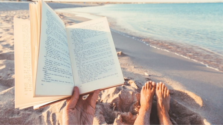 Find-Hope-and-Relief-from-Depression-Through-the-Magic-of-Reading A person reading a book on the beach with their feet in the sand | Find Hope and Relief from Depression Through the Magic of Reading | Mindful Health Solutions