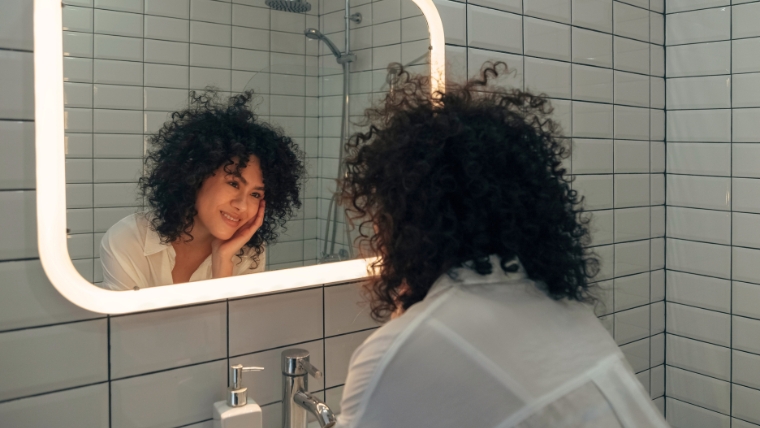 What-Are-Affirmations-and-Do-They-Actually-Help-What-To-Know A woman looking at herself lovingly in a mirror | What Are Affirmations and Do They Actually Help? What To Know | Mindful Health Solutions