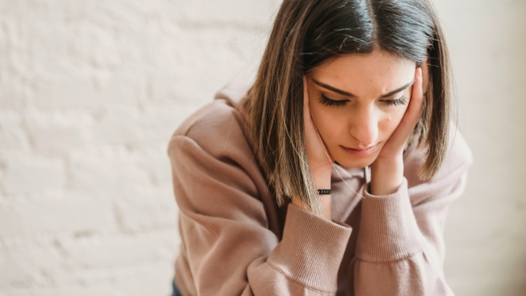 How-to-Manage-a-Breakup-When-You-Have-Depression-Practical-Advice A sad looking woman with her head in her hands | How to Manage a Breakup When You Have Depression Practical Advice | Mindful Health Solutions