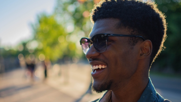Pain-Free-Promise-What-You-Need-to-Know-About-TMS-Therapy A man in sunglasses standing outside with a large smile on his face | Pain-Free Promise What You Need to Know About TMS Therapy | Mindful Health Solutions