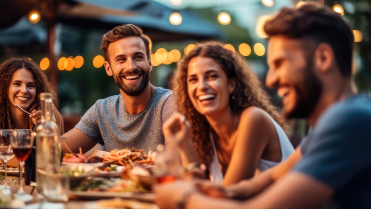 Friendships and Mental Health 7 Tips for Building and Maintaining Healthy Relationships Group of friends laughing and enjoying dinner at outdoor restaurant during summer | Friendships and Mental Health 7 Tips for Building and Maintaining Healthy Relationships | Mindful Health Solutions