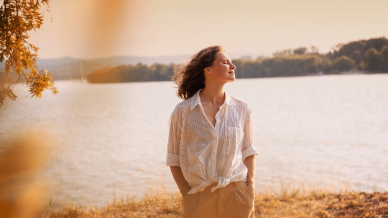 8 Practical Tips To Improve Your Self-Image Woman standing outside and being present with eyes closed and hands in pockets | 8 Practical Tips To Improve Your Self-Image | Mindful Health Solutions
